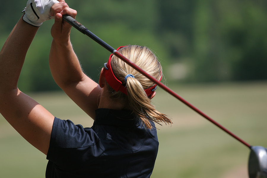 Lady golf swing at finish on golf course